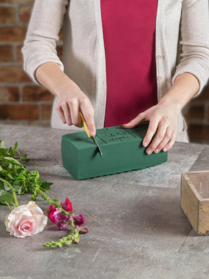 Florist cutting Instant Oasis Foam to make an arrangement